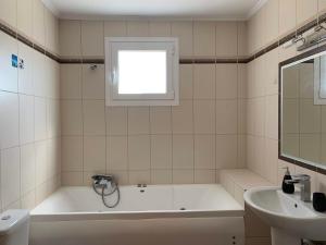 a white bathroom with a tub and a sink at Sea melodies apartment 1 in Koroni +45 photos