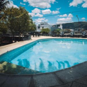 una piscina en un hotel con agua azul en Montecatini Hotel- By HVH en Villa Carlos Paz