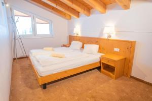 a bedroom with a bed with white sheets and a window at alpsrental Apartments Freja Obertauern in Obertauern