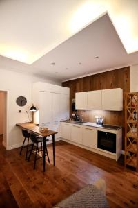 uma cozinha com armários brancos e piso em madeira em Town Hall Square Apartment em Taline
