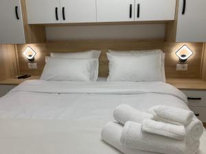 um quarto com uma cama branca e toalhas em Tirana Apartment em Tirana