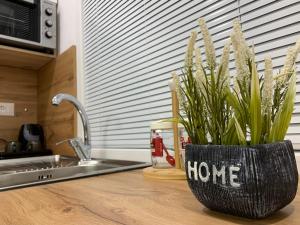 um vaso preto com casa escrito sobre ele sentado em um balcão da cozinha em Tirana Apartment em Tirana