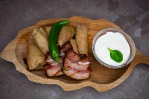 a plate of food with a green pepper and a sauce at Podina Resort Hotel & Spa in Ungureni