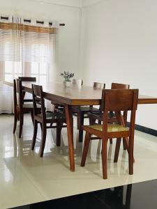 una mesa de comedor de madera y sillas en una habitación en Thalalla resort, en Talalla South