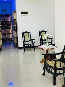 una habitación con 3 sillas y una mesa con un jarrón de flores en Thalalla resort, en Talalla South