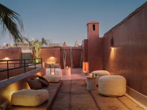 a rooftop patio with stools and tables on a building at Riad Brummell Medina in Marrakesh