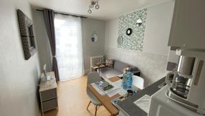 a small living room with a table and a kitchen at Résidence des Sources in Vichy