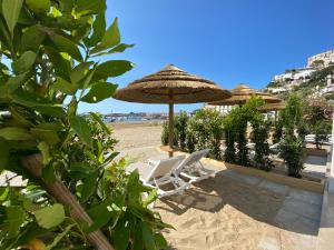 a pair of chairs and an umbrella on the beach at Marina Bay Beach Hotel in Peschici