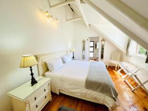 Dormitorio blanco con cama y lámpara en Summerhill Self-Catering Accommodation St Francis Bay, en St Francis Bay