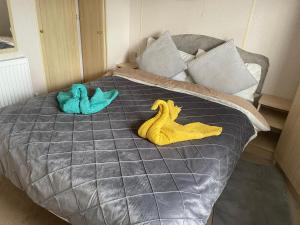 two stuffed animals sitting on top of a bed at Caravan F8 Aberystwyth Holiday Village in Aberystwyth