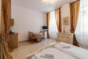 a bedroom with a bed and a table and a television at Апартаменти на Площі Ринок, 20 in Lviv