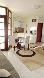 a living room with a table and chairs and a kitchen at Apartments Happy Day in Karlobag