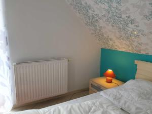 um quarto com uma cama e um candeeiro numa mesa de cabeceira em Achtern 8 em Horumersiel