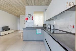 a kitchen with a counter and a clock on the wall at A fully equipped 3BR penthouse with large terrace by 360 Estates in Il-Gżira