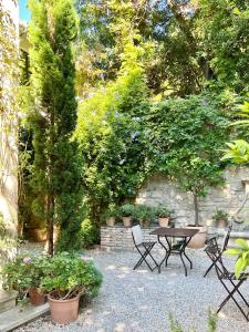 a patio with a table and chairs and plants at Le Clos Saluces in Avignon