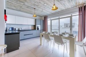 cocina y comedor con mesa y sillas en A fully equipped 3BR penthouse with large terrace by 360 Estates, en Il-Gżira