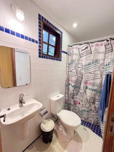 a bathroom with a toilet sink and a shower curtain at Casa Apu Honey Moon Suite Pague duas noites minimo e a terceira e brinde menos feriados in Natividade da Serra +28 photos