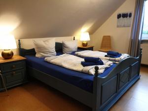 two beds in a bedroom with blue sheets and pillows at Deichgräfin 4 in Horumersiel