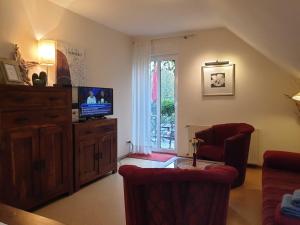 a living room with a tv and two chairs at Deichgräfin 3 in Horumersiel