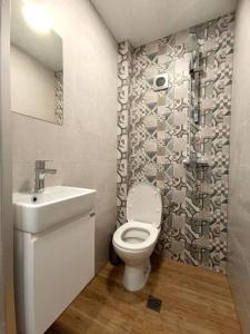 a bathroom with a toilet and a sink at Кокетен апартамент VeRa Suite in Silistra