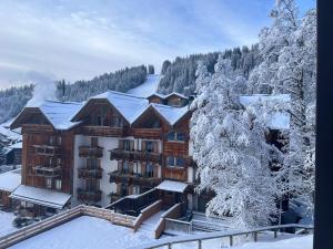 um hotel na neve com árvores cobertas de neve em Delizioso appartamento nelle Dolomiti em Madonna di Campiglio