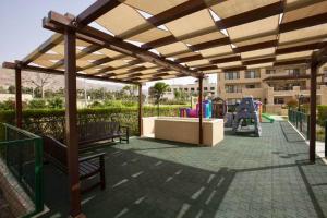 a pavilion with benches and a playground in a park at EP4 Samarah Resort in Sowayma