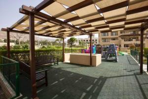 a pavilion with benches and a playground in a park at EP2 Samarah Resort in Sowayma