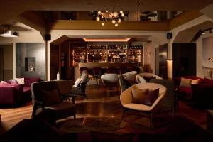 a room with chairs and a bar in the background at Loly Boutique Hotel Roma in Rome