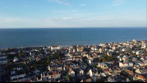 una vista aérea de una ciudad junto al océano en Chambres d'hôte dans une maison, Piscine, 5 minutes à pieds de la mer, en Saint-Aubin-sur-Mer