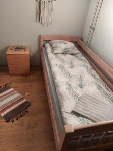 Cama en habitación con marco de madera en Rogosi mõisa apartment, en Ruusmäe