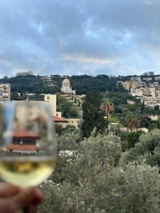 a person holding a glass of white wine at Via Maria Boutique Suites In The Middle Of The city in Haifa