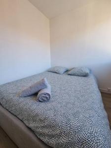 - un lit avec 2 oreillers dans l'établissement Le Landouzy - Parking - Netflix - Wifi, à Chamalières