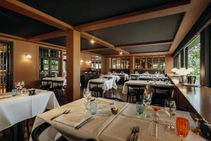 een restaurant met witte tafels, stoelen en ramen bij Charl's in Knokke-Heist