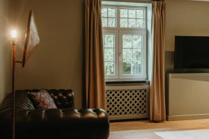 ein Wohnzimmer mit einem Ledersofa und einem Fenster in der Unterkunft Charl's in Knokke-Heist