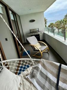 balcón con cama, silla y fogones en Departamento Primera Línea Av. Del Mar La Serena en Coquimbo