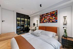 a bedroom with a large bed and a painting on the wall at Unique 1 Bedroom Luxury Haven In Central London in London
