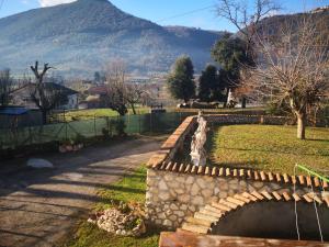 a stone bridge in a park with a mountain in the background at La quercia in Gavignano