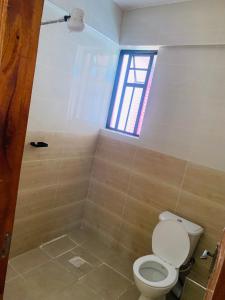 a bathroom with a toilet and a window at Rorot 1 bedroom annex Eldoret,Arlene in Eldoret