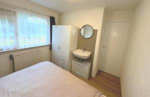 a bathroom with a bed and a sink and a mirror at Helmpol in Buren +15 photos