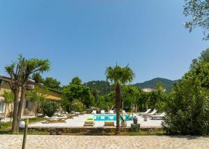 een resort met een zwembad en een palmboom bij Natura villa with jacuzzi in Limenas