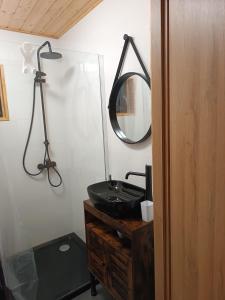 uma casa de banho com um lavatório preto e um espelho em Domki RESET em Polańczyk mais 37 fotografias