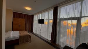 a bedroom with a bed and a large window at Civilization in Dnipro