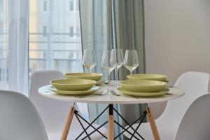 a table with plates and wine glasses on it at Cozy Apartment Klimasa with Balcony in Wrocław by Renters in Wrocław