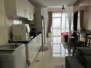 a kitchen with a microwave and a table and a room at Kyra Homestay Centrus SOHO Cyberjaya *wifi and pool* in Cyberjaya
