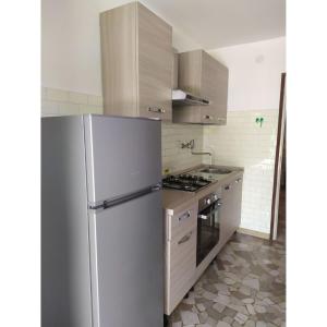 a kitchen with a refrigerator and a stove at Bright villa with private garden - Beahost Rentals in Caorle
