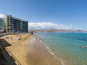 eine Gruppe von Menschen an einem Strand im Wasser in der Unterkunft Ok Las Canteras Beach by CanariasGetaway in Guanarteme