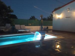 - une piscine avec une fontaine dans un jardin la nuit dans l'établissement Els Rosers - con jacuzzy XL y barbacoa, à Rodonyà