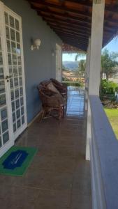 a porch of a house with a bench on it at Escarpas do Lago in Capitólio