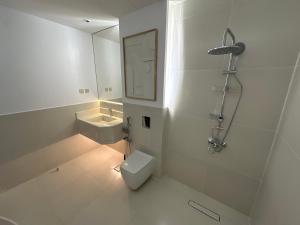 a bathroom with a toilet and a sink and a mirror at Divon Chalets in Buraydah