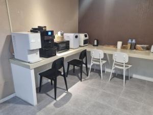 una cucina con sedie e bancone con macchinetta del caffè di CC Hotel a Busan